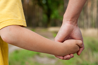 child holding hands with a parent